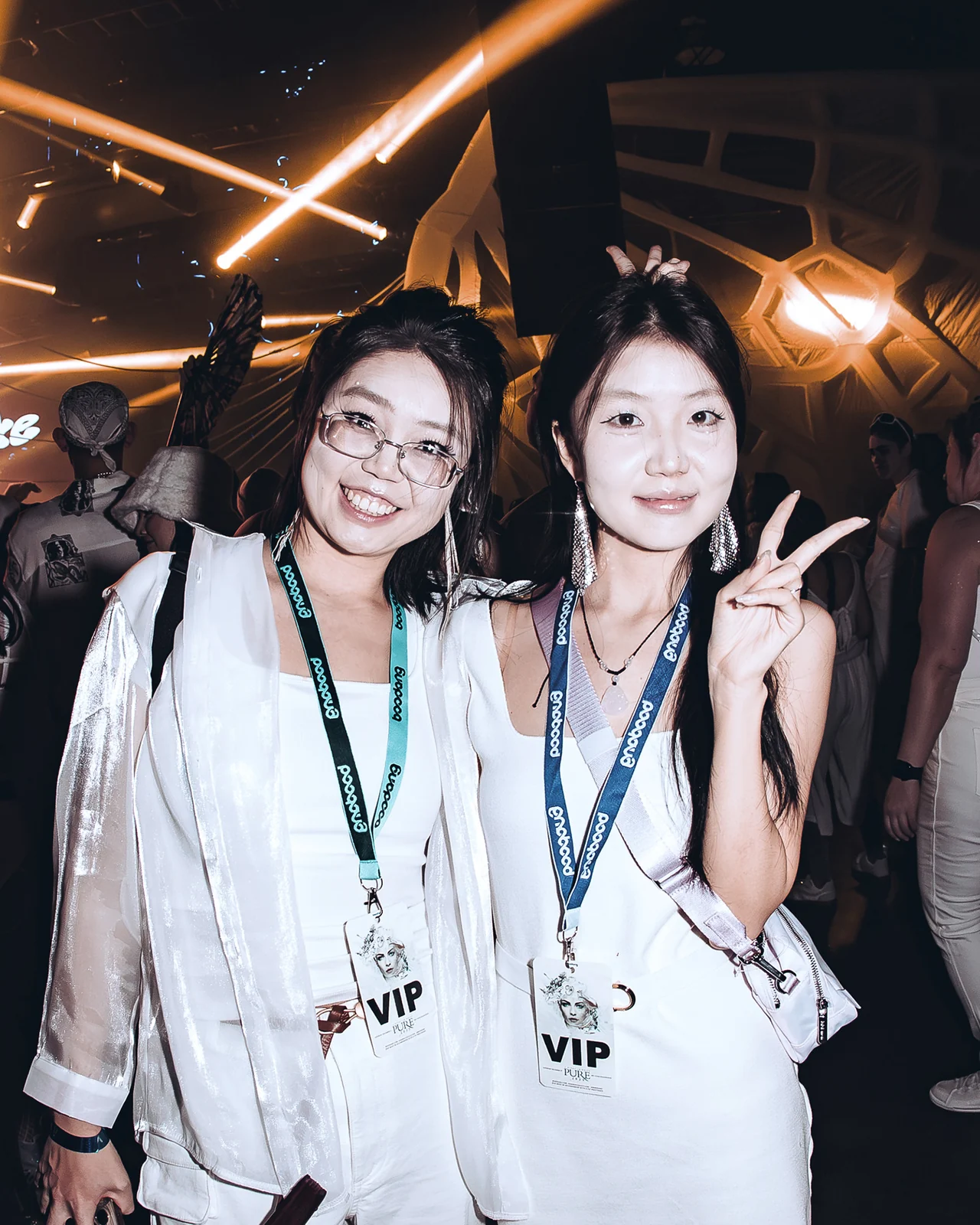 Two guests wearing VIP lanyards at PURE 2025