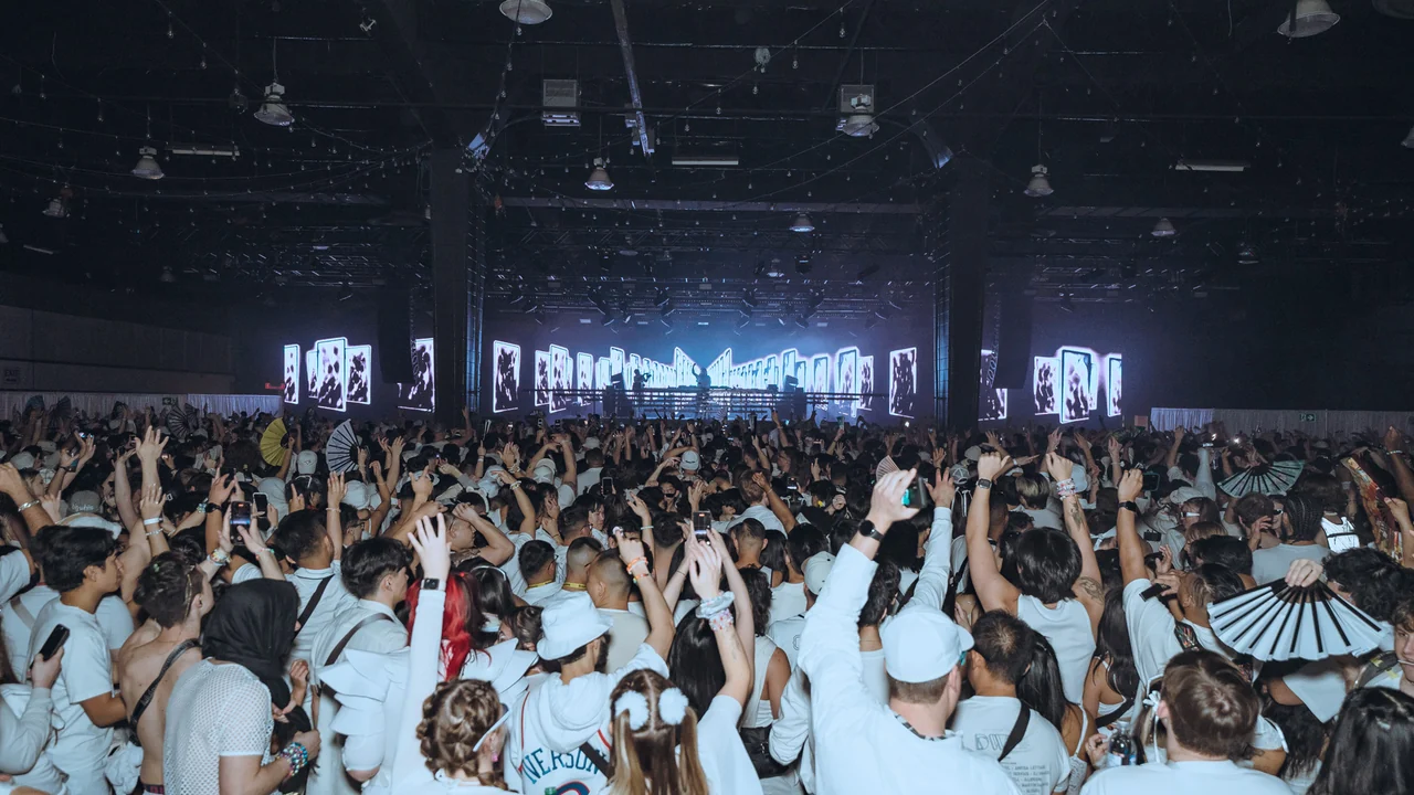 Hundreds of guests dressed in white facing the LED stage at PURE 2024