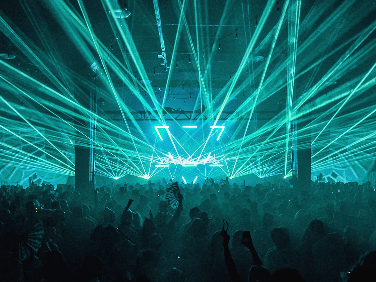 Green lasers fanning out over the crowd at PURE 2025