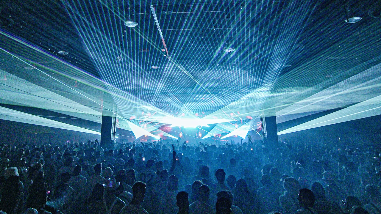 Wide shot of blue lasers sweeping over the packed PURE crowd